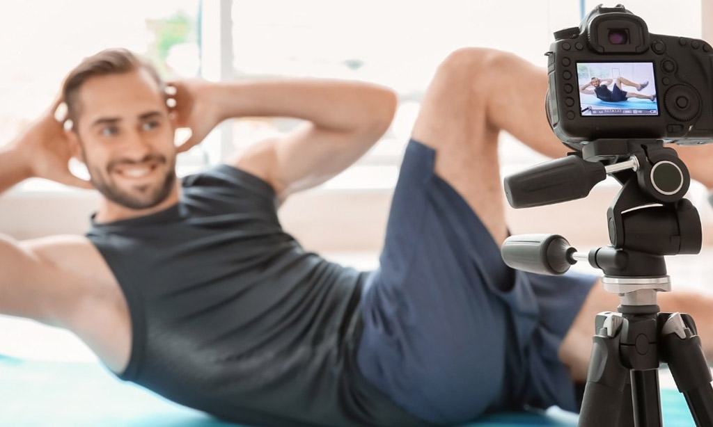 man making bicycle crunch on exercise mat and flexing abs at home